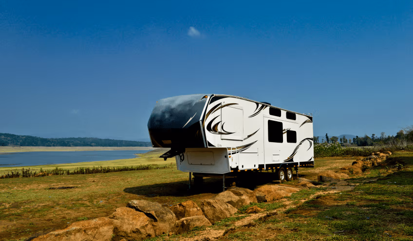 RV parked on ground near a lake