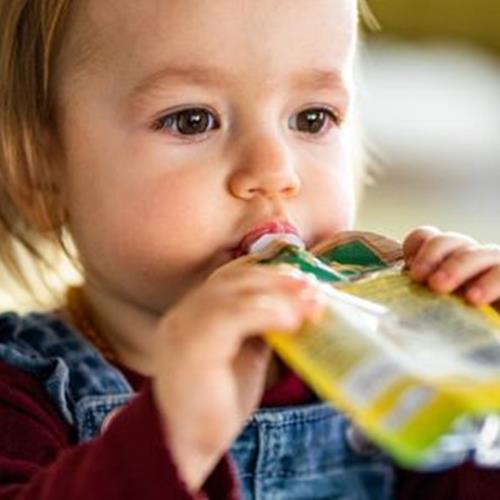 Little girl sipping juice from the pack