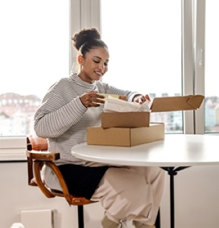 Woman opening packaging box on table