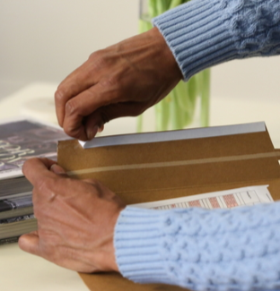 Person using adhesive coated tape for box packaging