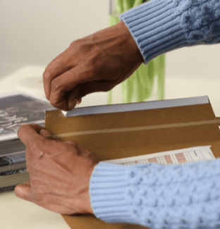 Person using adhesive coated tape for box packaging