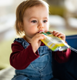 Little girl drinking from flexible pack