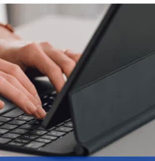 Person typing on keyboard attached to a tablet case
