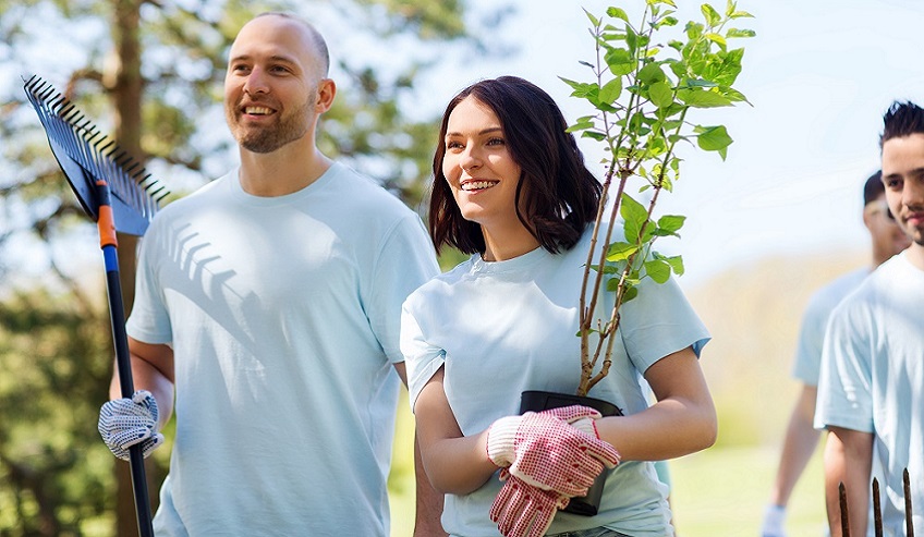 Volunteers planting a tree demonstrating corporate social responsibility. 
