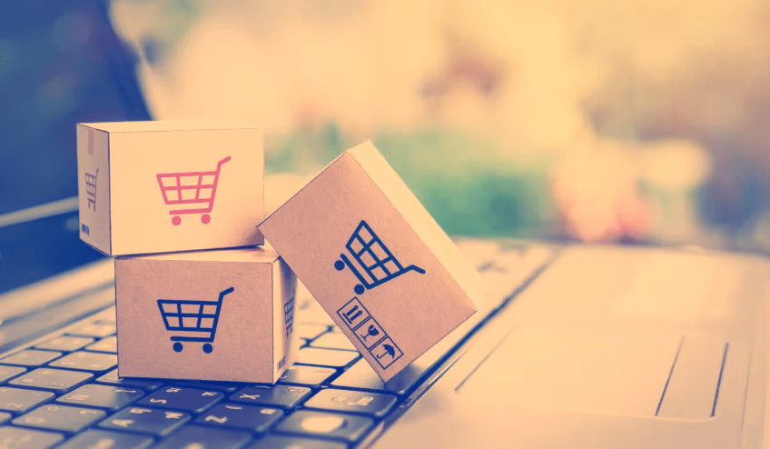 Shopping carts on tiny ecommerce  boxes on top of a laptop