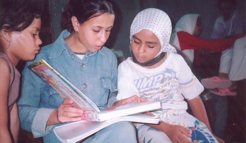 International woman reading a book in a group