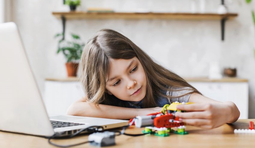 Child playing near a laptop