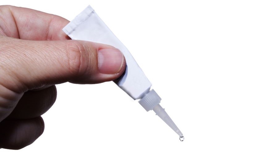 Bottle of super glue being squeezed