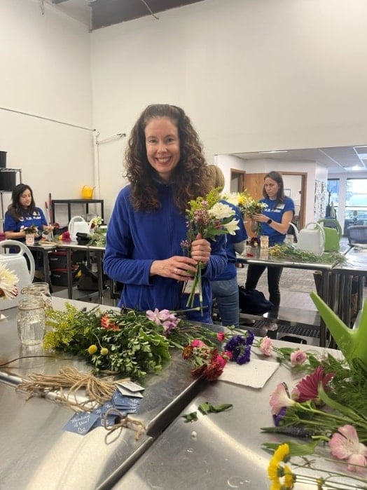 Funcionários da H.B. Fuller montando arranjos florais para Bluebirds and Blooms