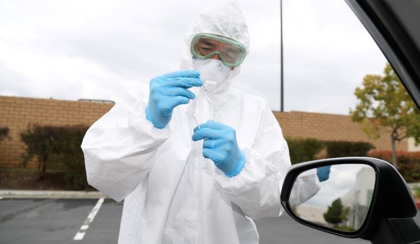 Person in protective gear testing for disease
