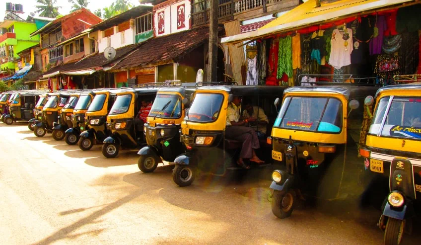 Three wheeler auto rickshaws parked in a row