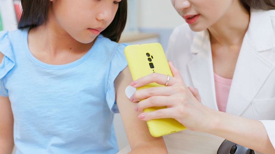 Woman using the phone's NFC capability to scan the sensor and get a reading