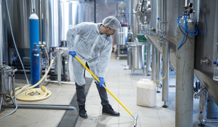 Industrial worker cleaning floor