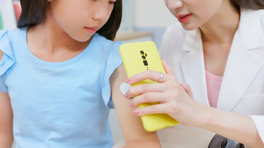Woman using the phone's NFC capability to scan the sensor and get a reading